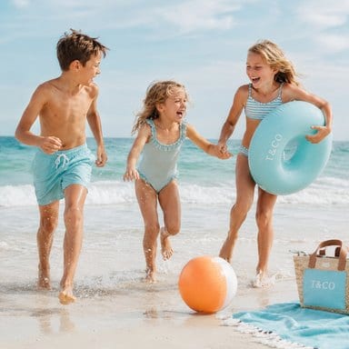 Children playing with a swim ring at the water's edge