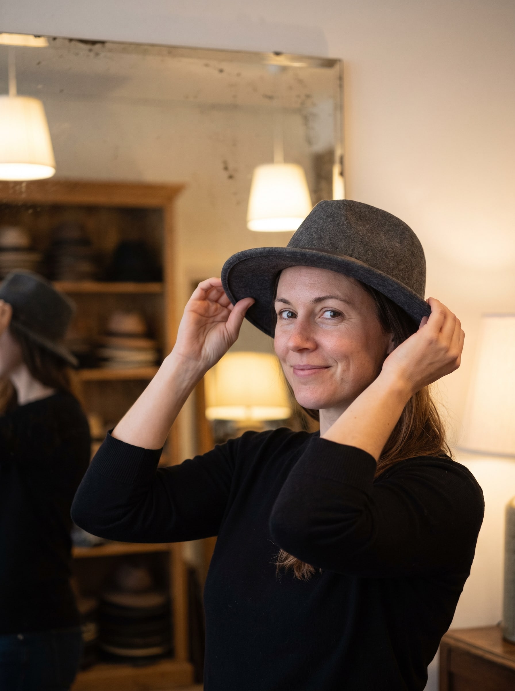 Woman trying on a grey felt hat in a boutique